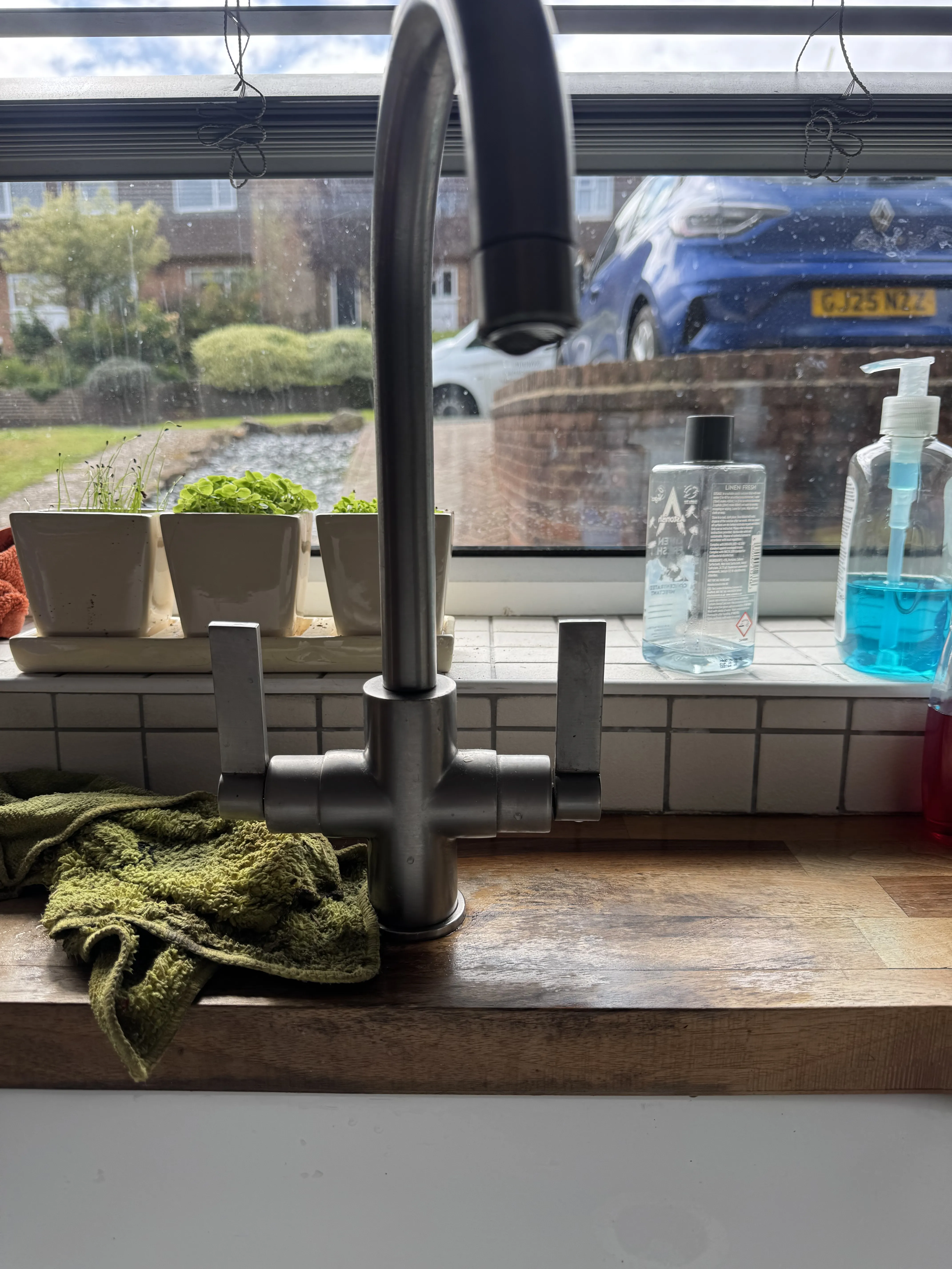 Modern kitchen mixer tap on butcher block worktop