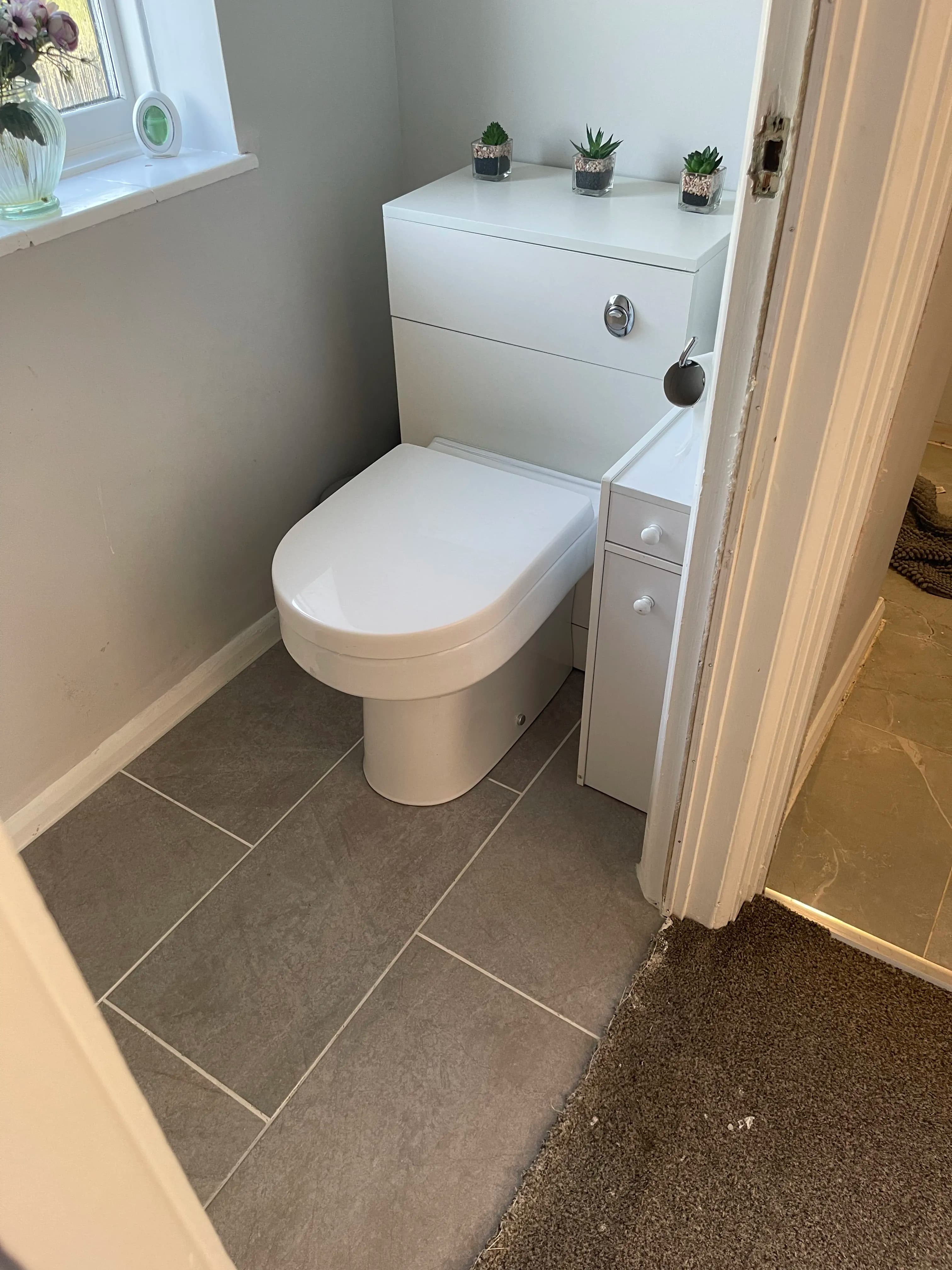 Modern toilet and vanity unit with grey floor tiles