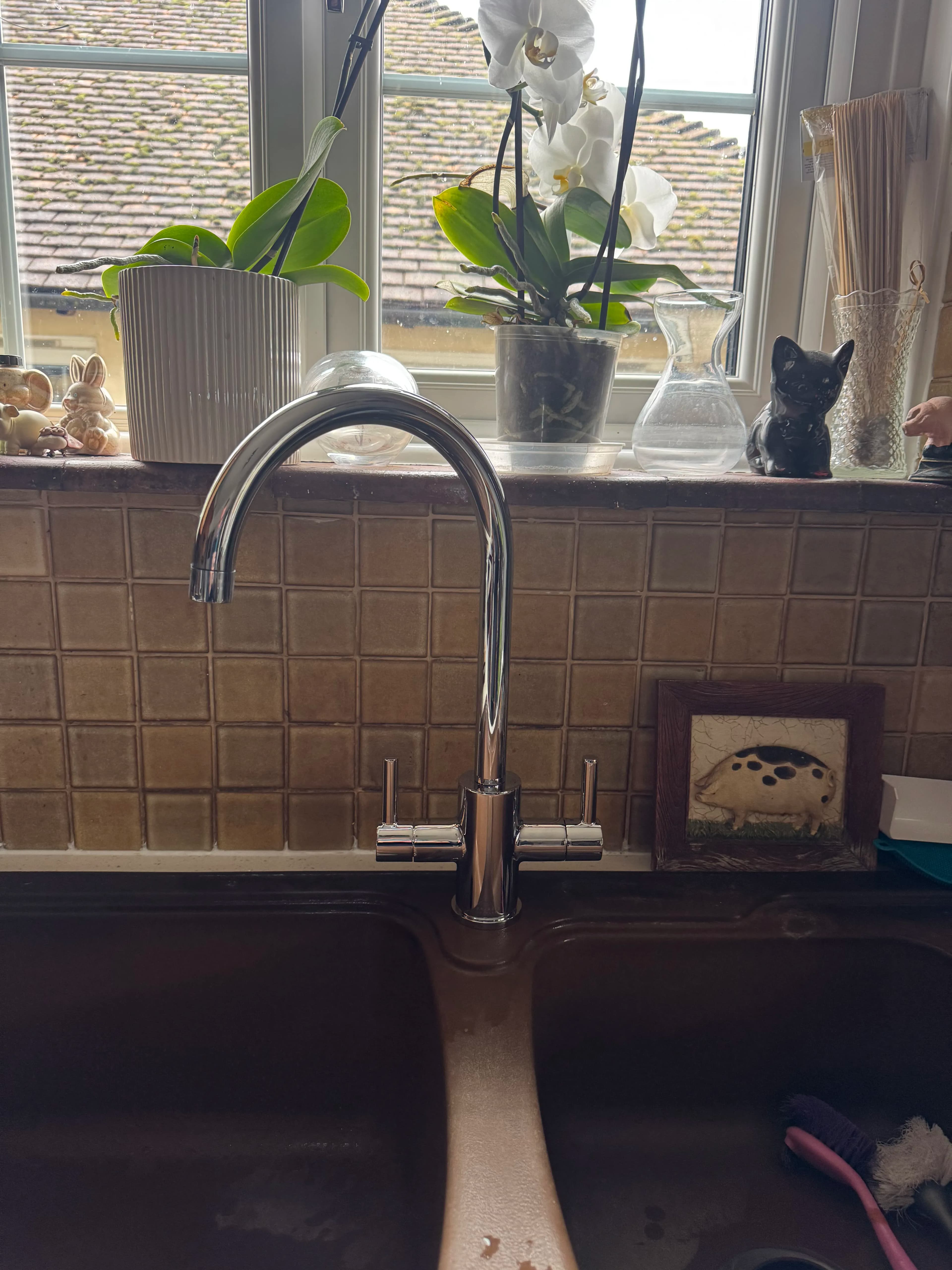 Chrome kitchen mixer tap with tiled splashback